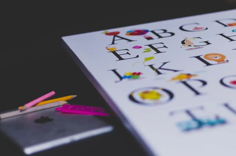 Colorful alphabet chart on a desk with pencils