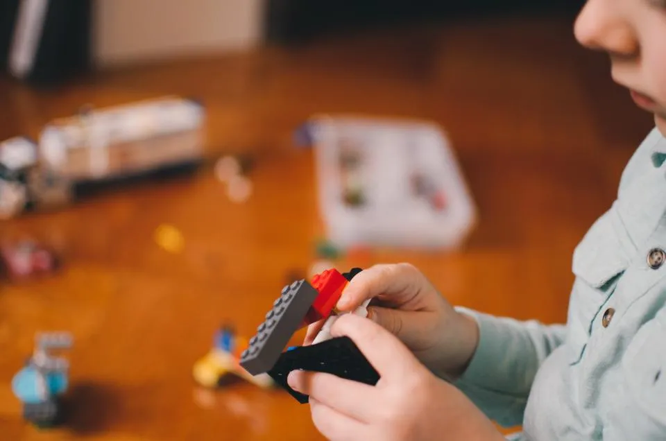 Child building with plastic toy bricks